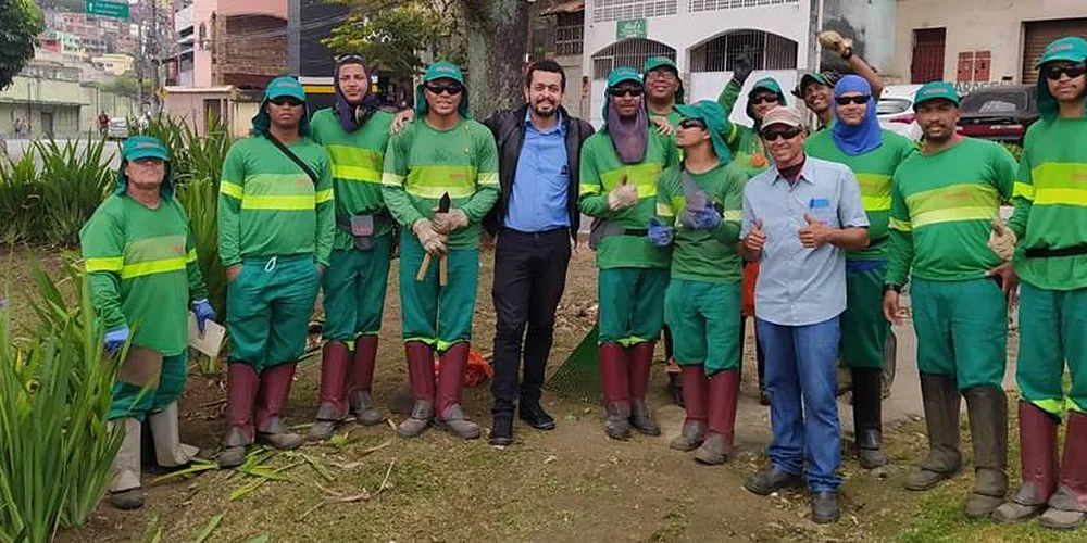 Equipe de manutenção com uniforme verde e capacetes em área externa