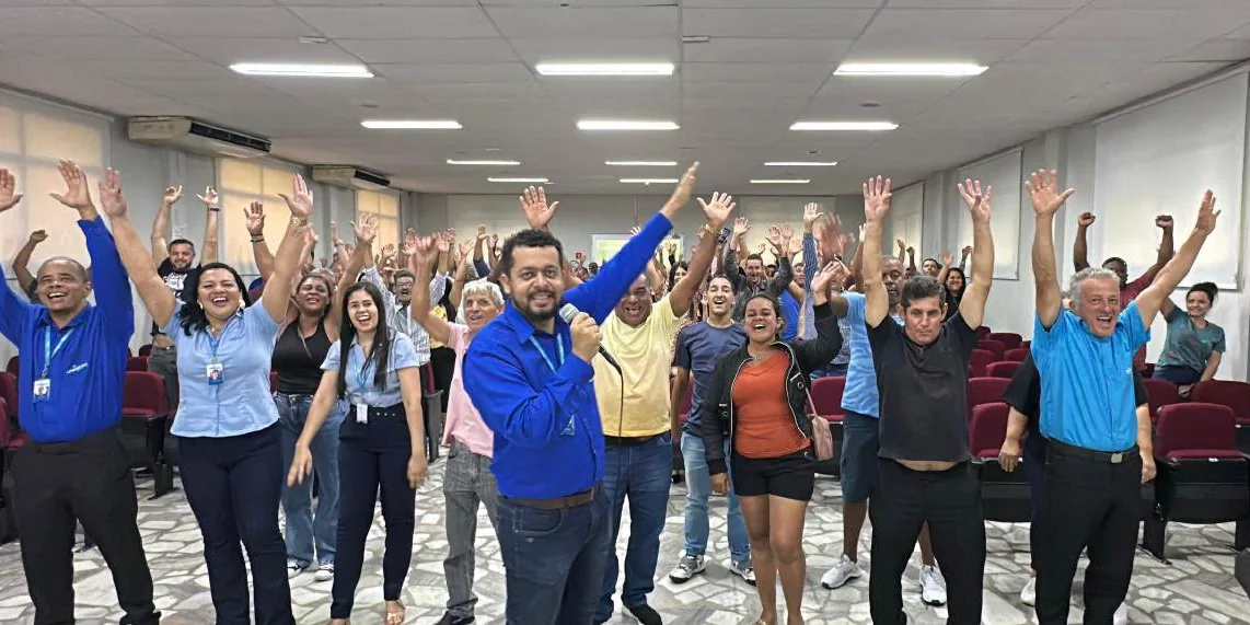 Participantes de palestra de segurança do trabalho comemorando em um auditório