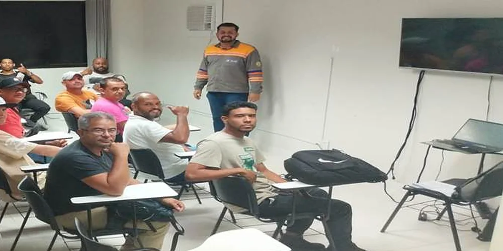 Turma sentada em sala durante treinamento de norma regulamentadora