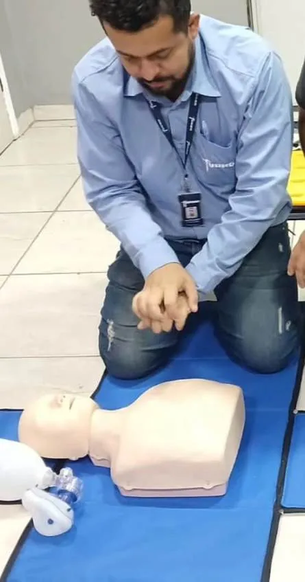 Willyam Souza demonstrando massagem cardíaca em manequim durante treinamento de primeiros socorros